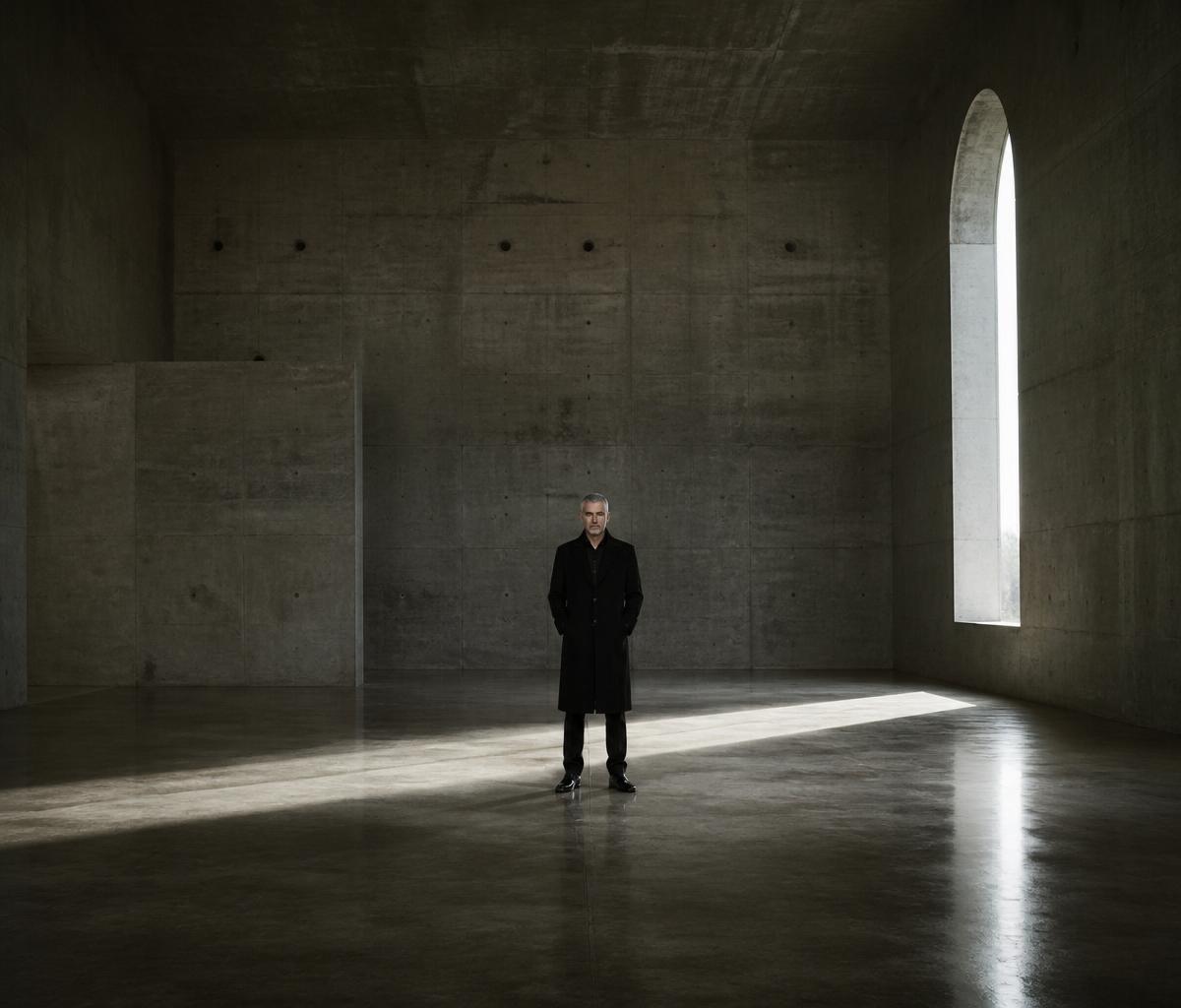Adrian Vale — small figure in vast brutalist concrete gallery, arched light